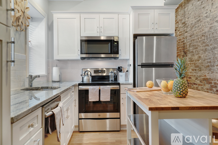 A kitchen with white cabinets and a wooden island.