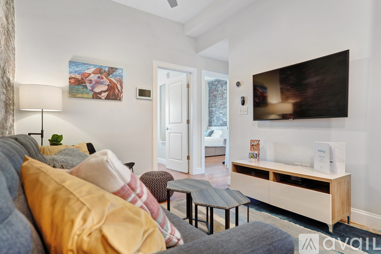 A living room with a couch, a coffee table, and a painting on the wall.