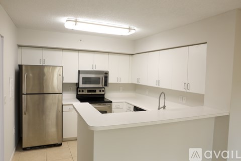 A kitchen with white cabinets and a stainless steel refrigerator.
