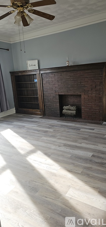 A room with a fireplace and a ceiling fan.