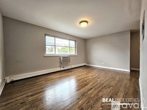 A room with wooden flooring and a window.