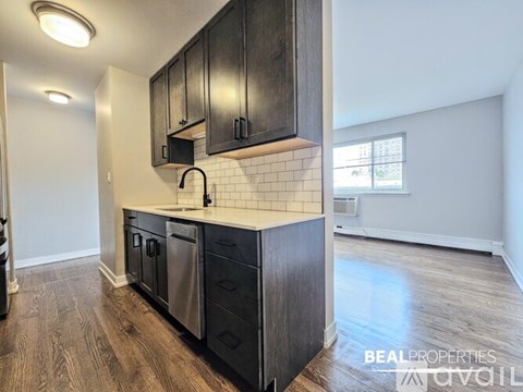 A kitchen with black cabinets and a white subway tile backsplash.