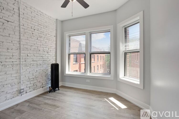A room with a white brick wall and a window overlooking a building.
