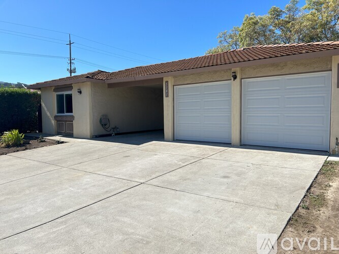 A house with a white garage door and a brown roof.