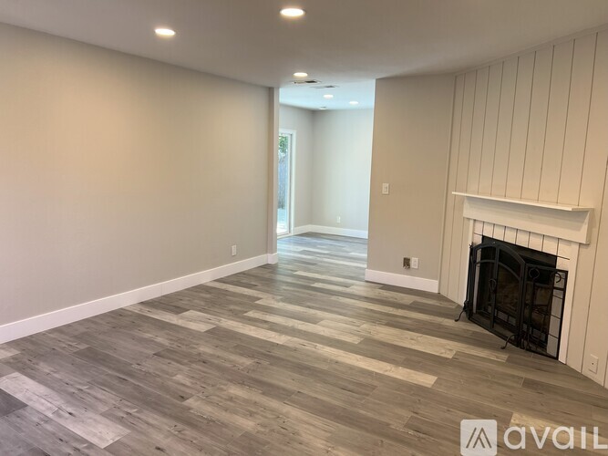 A room with a fireplace and wooden flooring.