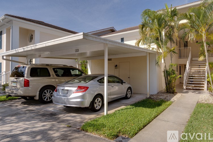 Two cars are parked in front of a house with a white garage.