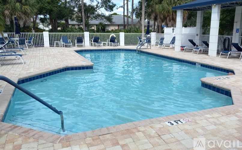 A pool with a blue tiled edge and a black metal railing.