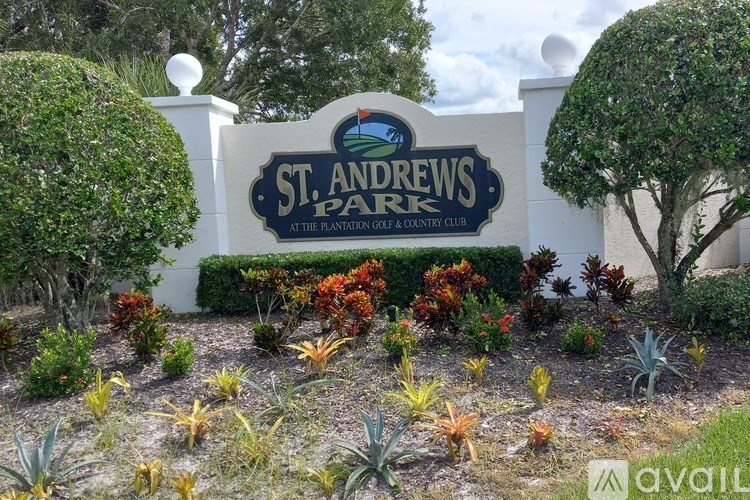 A sign that says St. Andrew's Park in front of some bushes.
