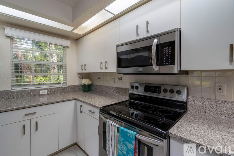 A kitchen with a stove, microwave, and cabinets.