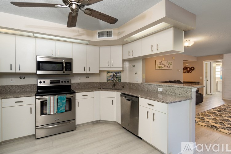 A kitchen with white cabinets and a stainless steel oven.