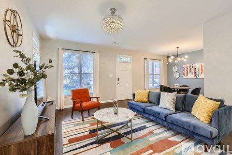 A living room with a blue couch and a white coffee table.