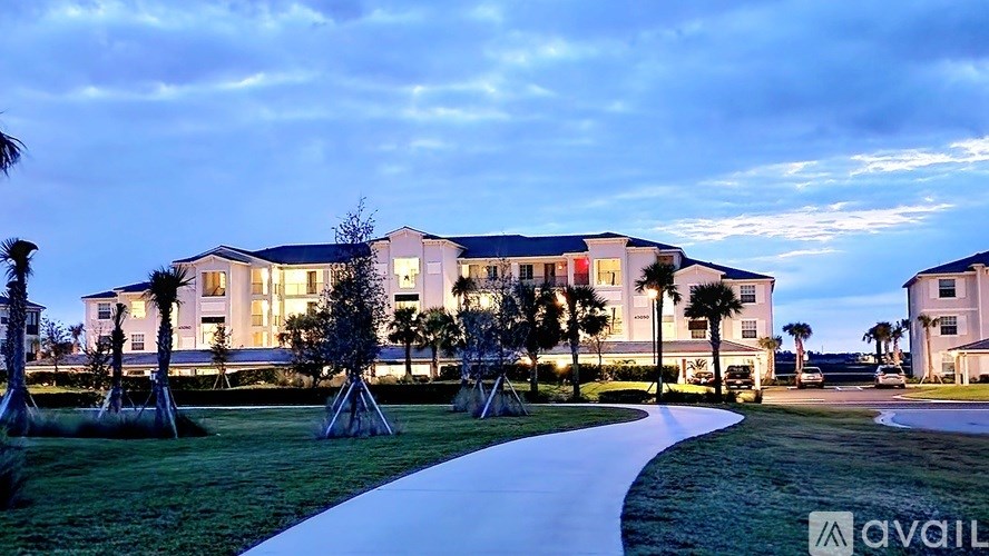 A modern building with a well-maintained lawn and trees in front.