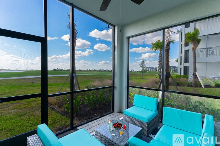 A balcony with a table and chairs overlooking a field.