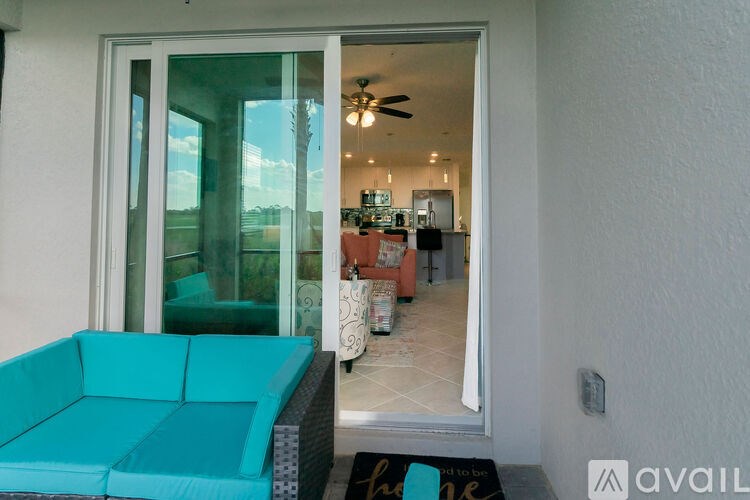 A living room with a blue couch and a fan.