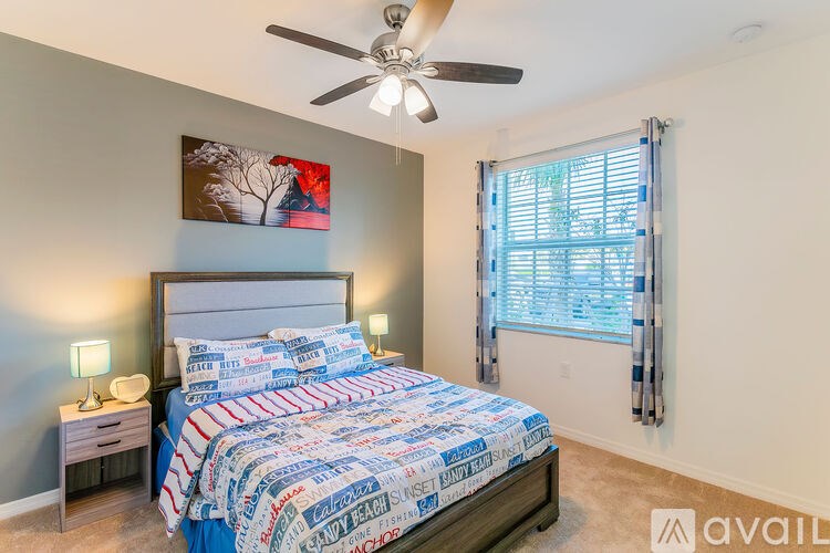 A bedroom with a bed, nightstand, and a ceiling fan.