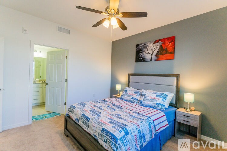 A bedroom with a bed, nightstand, and a ceiling fan.