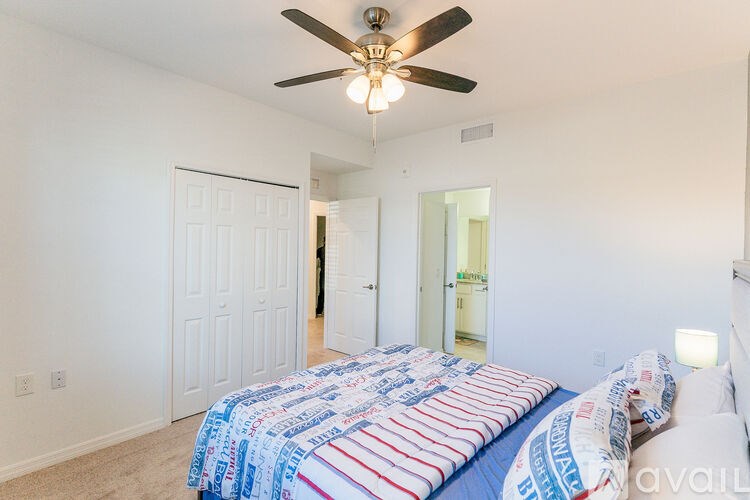 A bedroom with a bed covered in a blue and red comforter.