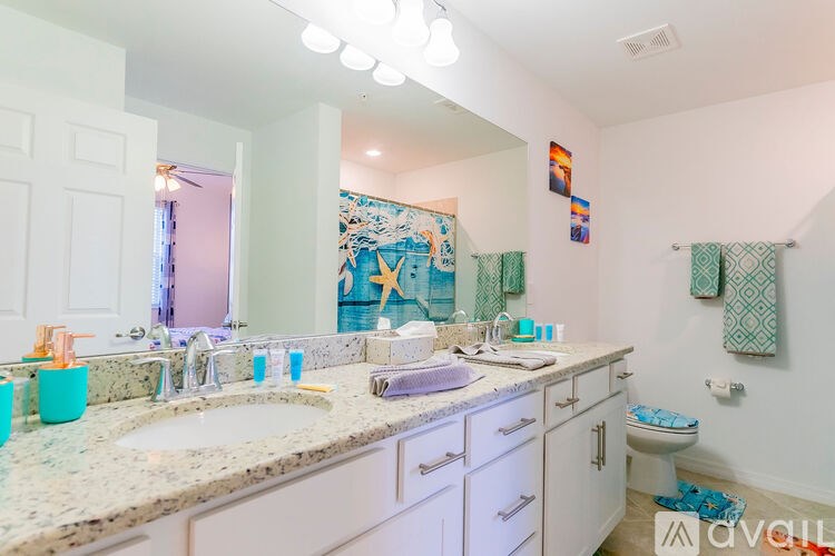 A bathroom with a sink, toilet, and a mirror.