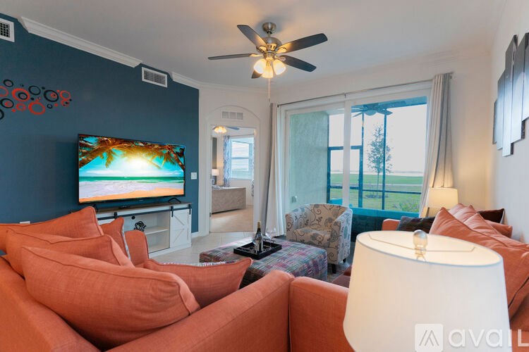 A living room with a television and orange couches.