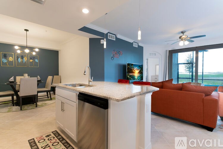 A modern kitchen with a large island and a dining area with chairs.