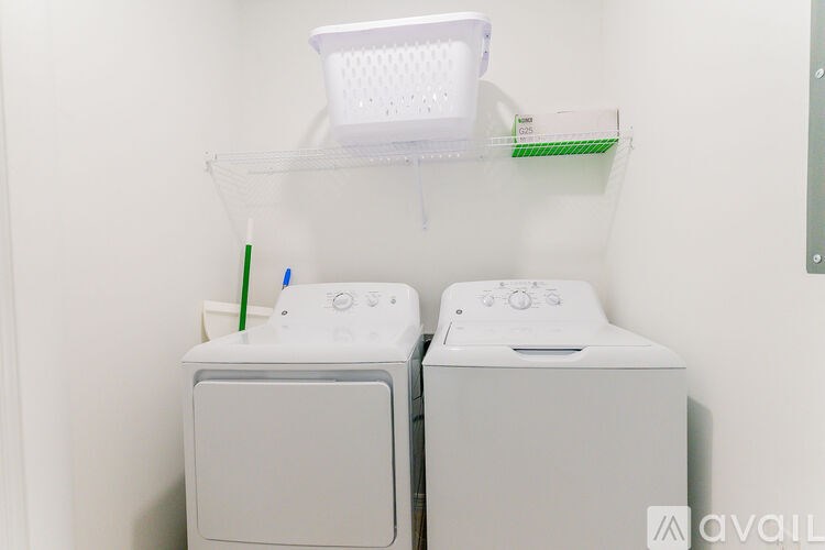 Two white washing machines are in a laundry room.