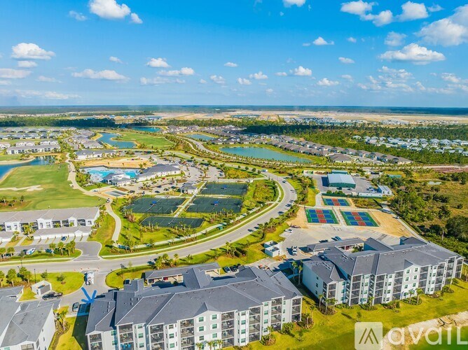 A bird's eye view of a residential area with multiple buildings and a large green space.