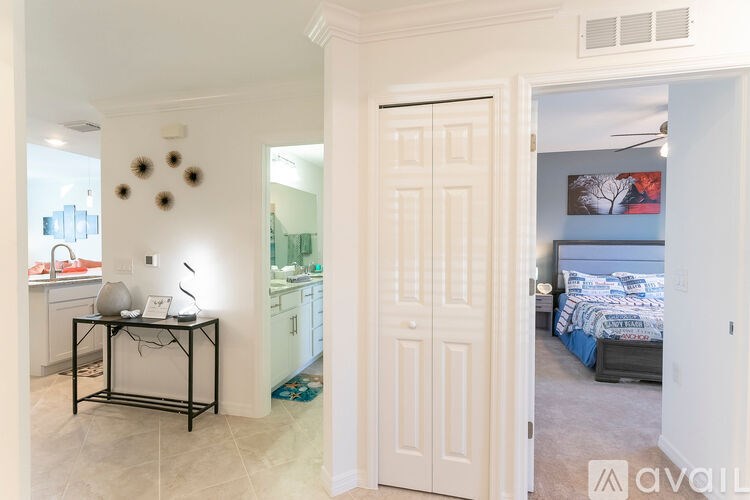 A room with a bed, a table with a lamp and a vase on it, and a wall with circular decorations.