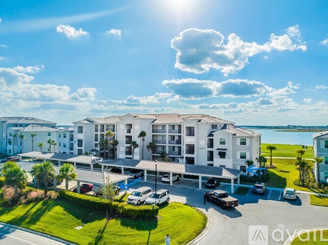 A sunny day at the beachfront hotel with cars parked in the lot.