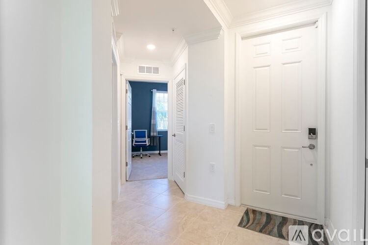A hallway with a white door and a tiled floor.