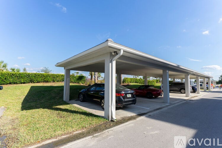 A carport with two cars parked inside.