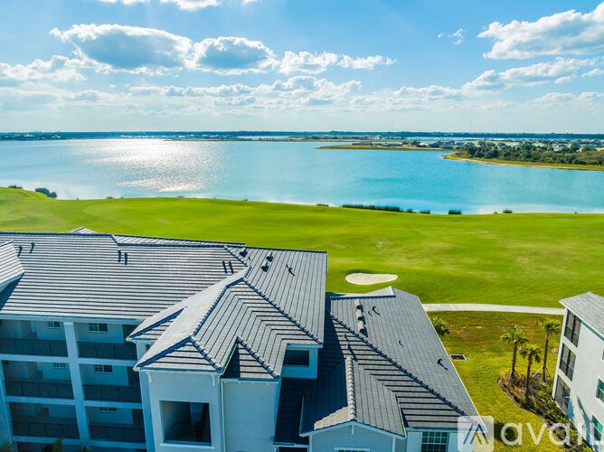 A view of a golf course from a high angle with a building in the foreground.