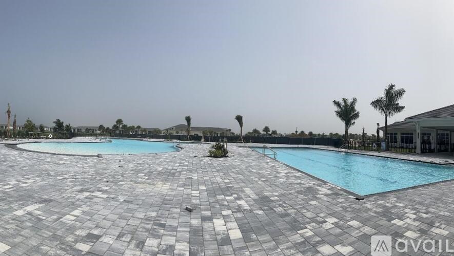 A large outdoor swimming pool surrounded by a tiled floor.