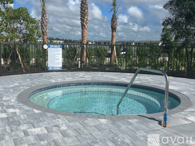 A round pool surrounded by a black fence with a sign that says "Spa Rules" and "No Diving".