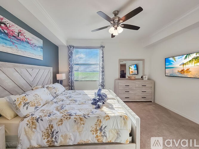 A bedroom with a large bed and a ceiling fan.