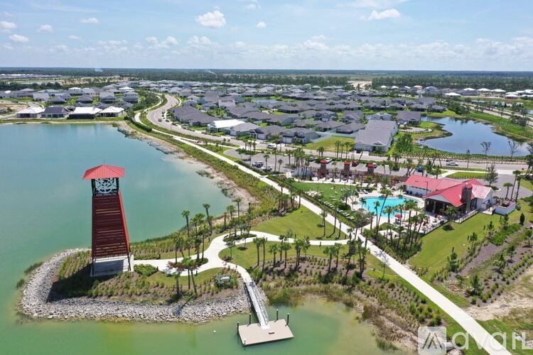A lighthouse stands on a small island in a large body of water.