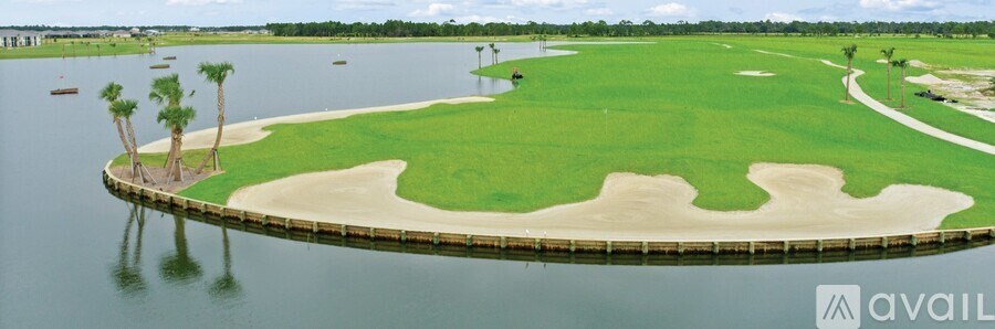 A golf course surrounded by water with palm trees.