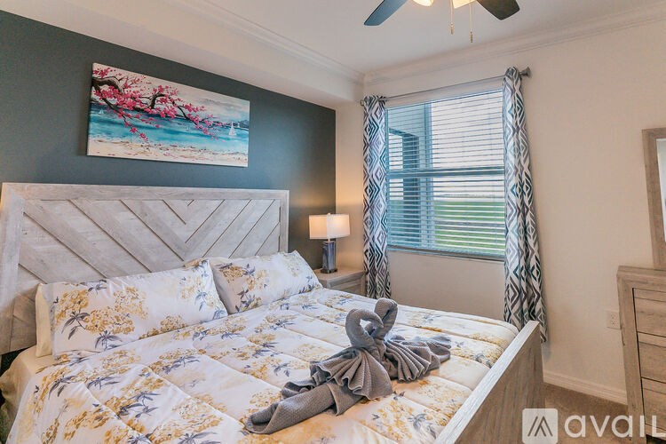 A bedroom with a large bed and a ceiling fan.