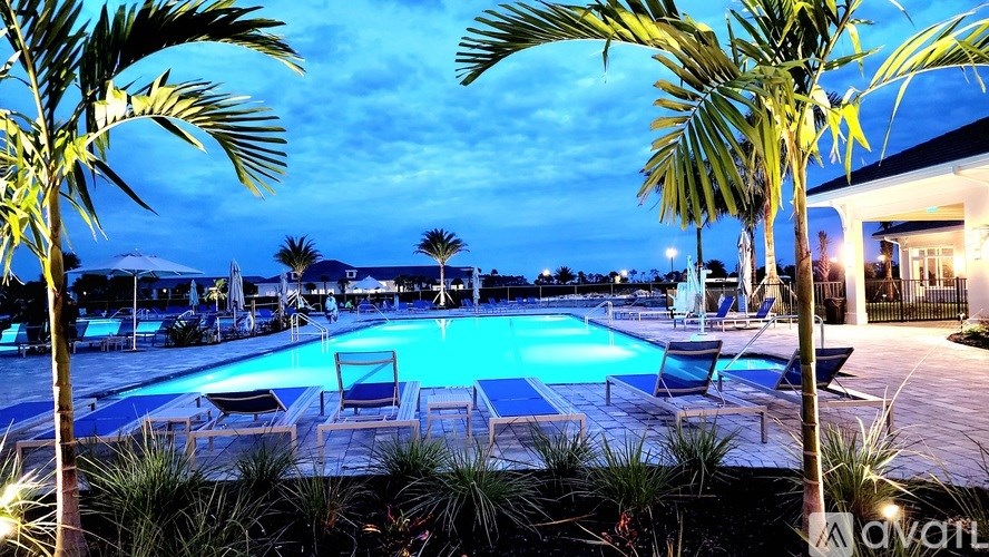 A pool surrounded by palm trees at dusk.