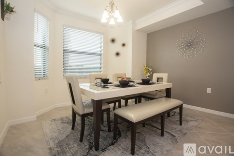 A dining room with a table set for two and a bench.