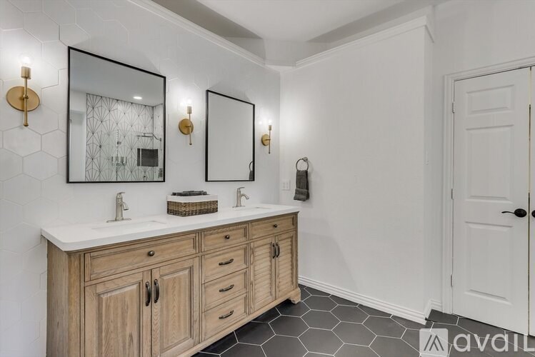 A bathroom with a white countertop and a wooden vanity.