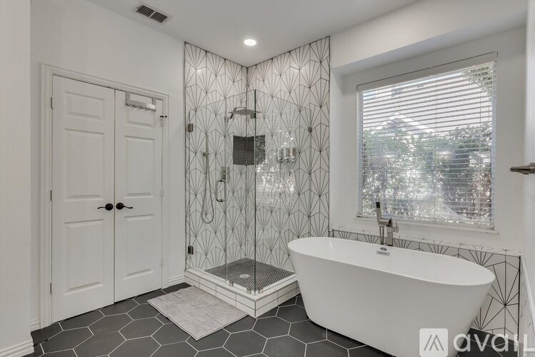 A white bathroom with a black and white tiled floor.