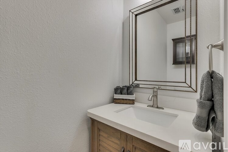 A bathroom with a white sink and a mirror.