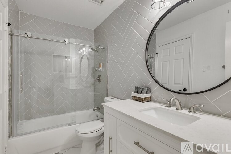 A bathroom with a white toilet, sink, and shower.