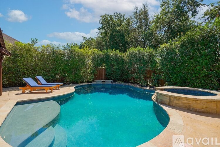 A swimming pool surrounded by a wooden fence and trees.