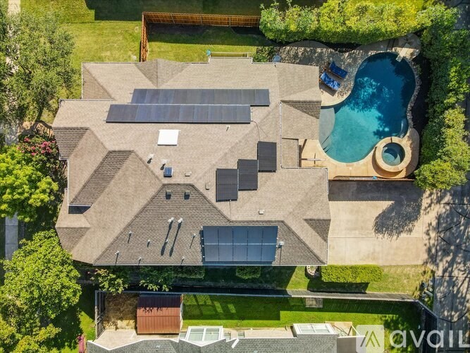 A house with a pool and solar panels on the roof.