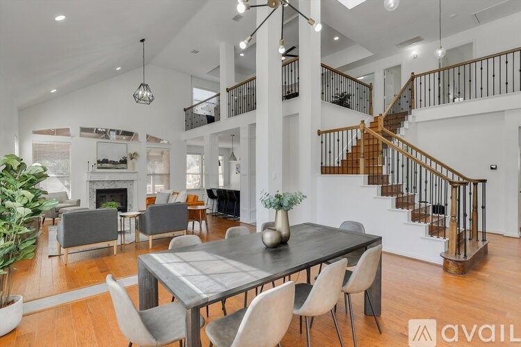 A modern dining room with a wooden table and chairs.