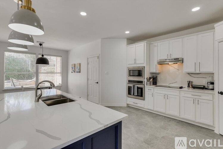 A modern kitchen with white cabinets and a large island.
