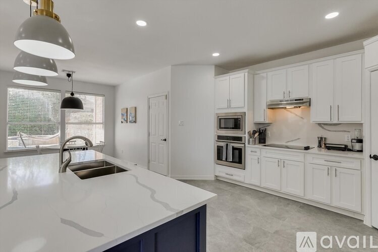 A modern kitchen with white cabinets and a large island.