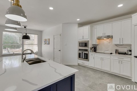 A modern kitchen with white cabinets and a large island.