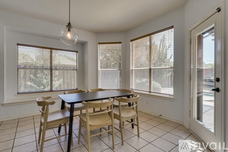 A dining room with a table and chairs.